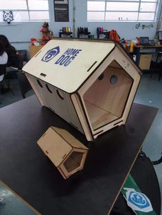 an open cardboard box sitting on top of a table in a room with people working behind it