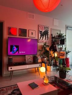 a living room filled with furniture and a flat screen tv on top of a wooden table