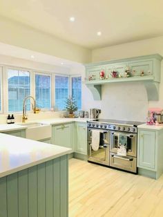 a kitchen with green cabinets and white counter tops