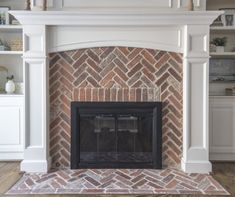 a brick fireplace in a living room with white bookcases