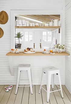 two white stools sitting in front of a counter with food on top of it