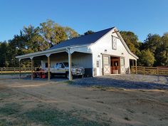 a truck is parked in front of a barn