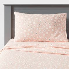 a bed with pink and white polka dot sheets