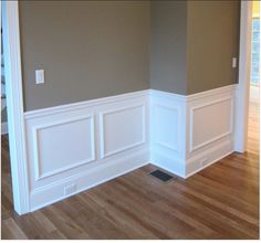 an empty room with hard wood floors and white wains on the walls, painted in neutral colors