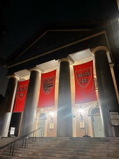 two red banners are hanging on the side of a building with steps leading up to it