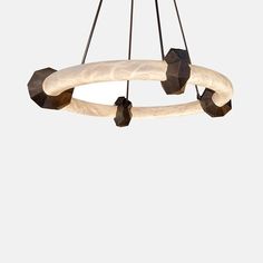 a circular light fixture hanging from a metal rod with white marble and black wood accents