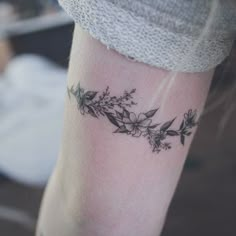 a woman's arm with flowers and leaves tattoo on the left side of her leg