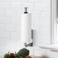 a roll of toilet paper is hanging on the wall next to some fruit and vegetables