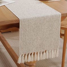 a table with a white table runner on top of it next to a wooden table