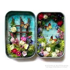 two tins filled with flowers and butterflies