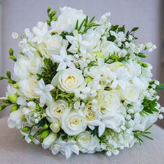 a bouquet of white flowers sitting on top of a chair