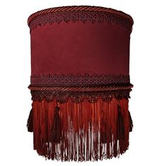 a red lamp shade with tassels hanging from it