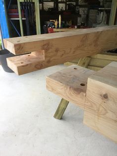 two pieces of wood sitting next to each other on top of a white floor in a garage