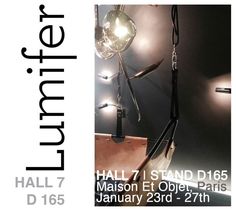 a poster for an art exhibition with lights on the wall and hanging objects in front of it