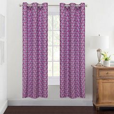 a window with purple curtains and a wooden dresser in front of it on a hard wood floor