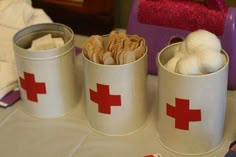 two tins filled with cookies and marshmallows on top of a table