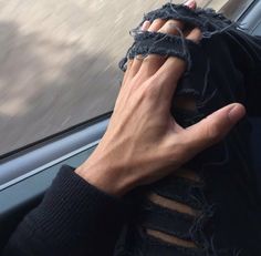 a man holding his hand up to his face as he sits in the back seat of a car