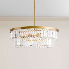 a chandelier hanging from the ceiling in a room with white walls and gold trim