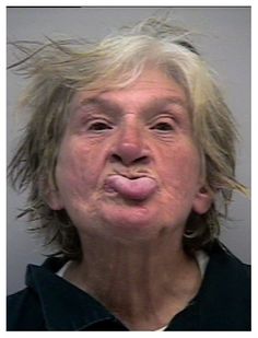 an older woman making a funny face with her tongue out and hair blowing in the wind