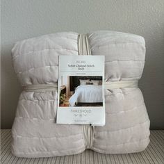 there is a white comforter on top of two pillows that are stacked up in front of each other