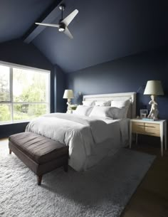 a bedroom with blue walls and white bedding