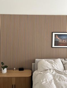 a bedroom with striped wallpaper and a bed in the corner next to a night stand