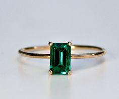 "This beautiful Emerald Gold Ring was handmade in Melt'm Jewelry Design Studio in California using 14k solid yellow gold band and 6x4mm emerald cut lab grown emerald stone. Emerald is featuring in 14k gold prong setting. DETAILS ABOUT THE RING, MATERIAL AND STONES Ring Band: 14K solid gold Ring Band size: 1 mm thick Gemstone: Lab grown Emerald Emerald size: 6mm x 4mm emerald cut Yellow gold or white gold options available from drop down menu. On the video shown 3 diamonds curved wedding band als Classic Green 14k Gold Stackable Rings, Elegant Stackable 14k Gold Emerald Ring, Emerald Cut Gemstone Stackable Rings In 14k Gold, Minimalist 14k Gold Emerald Ring With Prong Setting, Classic Emerald Gemstone Stackable Rings, Emerald Cut Solitaire Stackable Rings In 14k Gold, Classic 14k Gold Stackable Rings For May Birthstone, Minimalist 14k Gold Emerald Ring For Formal Occasions, Minimalist Yellow Gold Emerald Ring Round Band