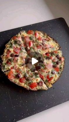 a pizza sitting on top of a black cutting board