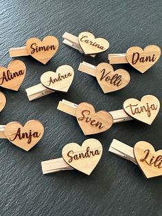 wooden name badges with names on them in the shape of hearts, arranged around each other