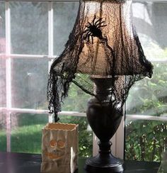 a spider lamp sitting on top of a wooden table next to a bag and window