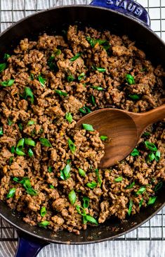 a skillet filled with ground beef and green onions