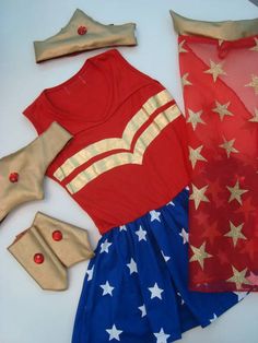 an assortment of costume and accessories laid out on a white surface, including red shirt with gold stars