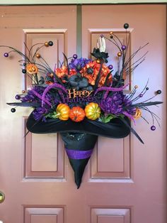 a door decorated for halloween with pumpkins and witch hats