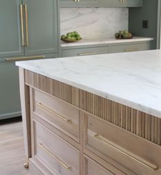 a kitchen with green cabinets and marble counter tops on the island in front of an oven