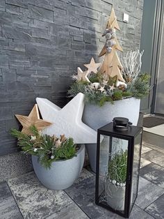 two cement planters with plants in them and a lantern on the ground next to it