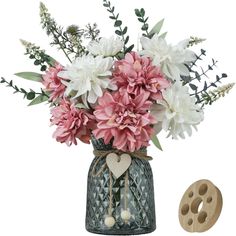 a vase filled with pink and white flowers next to a wooden heart shaped decoration piece