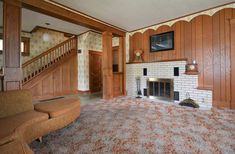 an empty living room with wood paneling and fireplace