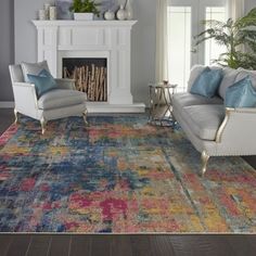 a living room with two couches and a rug in front of a fire place