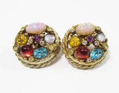 Vintage 50s Fancy Stone Cluster Clip Earrings set in rope design gold tone metal. There are multi-color "gems" including faux opal, turquoise and purple faceted rhinestones, moonstone, gold star cabachon and high red cabachon along with several smaller bezel set stones.  Earrings are 1-1/8" in diameter and almost a 1/2" in depth  - ummarked In very good vintage condition - please check over images. ---------------- Slight imperfections you may see in these blown-up close-ups would be difficult t Cameo Bracelet, Stones Earrings, Multicolor Earrings, Fancy Stones, Color Earrings, Sterling Silver Marcasite, Turquoise And Purple, Colored Stone, Rope Design