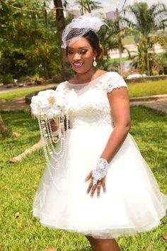 a woman in a white dress and headpiece is posing for the camera with her hands on her hips