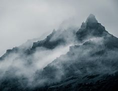 the mountains are covered in fog and clouds