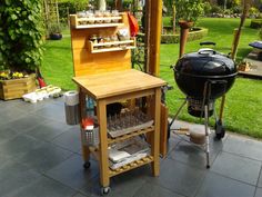 an outdoor bbq and grill on a patio with green grass in the back ground