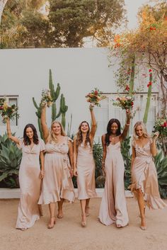 the bridesmaids are holding their bouquets and posing for a photo in front of some cacti