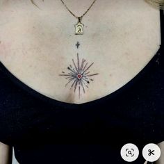 a woman wearing a black top has a star tattoo on her chest