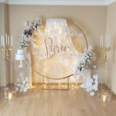 a white wedding arch decorated with flowers and candles