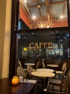 the inside of a coffee shop with tables and chairs in front of a window that reads cafe noir