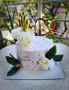 a cake decorated with white flowers and greenery