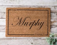 a welcome mat with the word, the murphy on it next to a potted plant