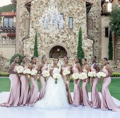 a group of women standing next to each other in front of a castle style building