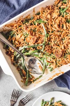 a casserole dish filled with green beans and fried onions on a blue towel